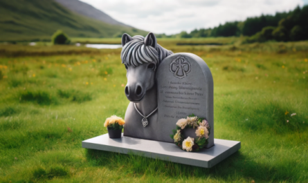 Una imagen horizontal de una lápida conmemorativa en un campo de hierba para un Connemara Pony fallecido. La lápida es modesta, de piedra gris y tiene una inscripción tallada dedicada al pony. Alrededor de la base de la lápida se colocan flores y una pequeña corona. El fondo presenta una pradera verde y tranquila con algunos árboles y un cielo sereno. https:www.lapidasparamascotas.com